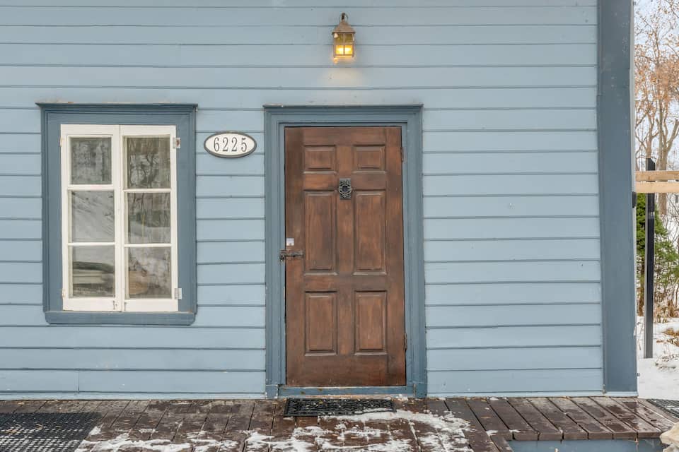 Blue wooden facade of La Petite École de l'Île d'Orléans (1839) with its 6225 house-number plate, Chemin Royal, Saint-Laurent-de-l'Île-d'Orléans